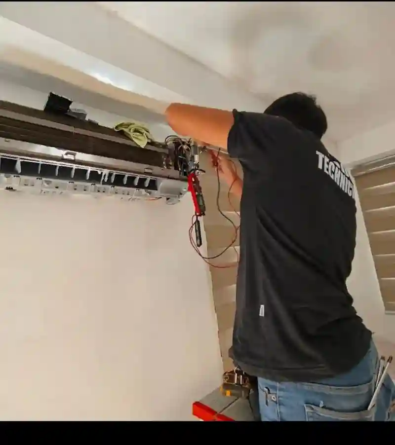 Certified AC mechanic repairing a Samsung split unit system in Al Barsha, Dubai.